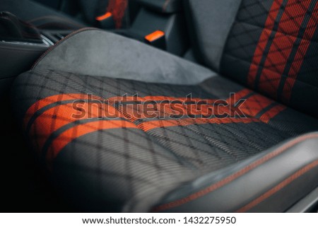 Modern car fabric sports seats with red stripes close up. Driver seat of modern sport car