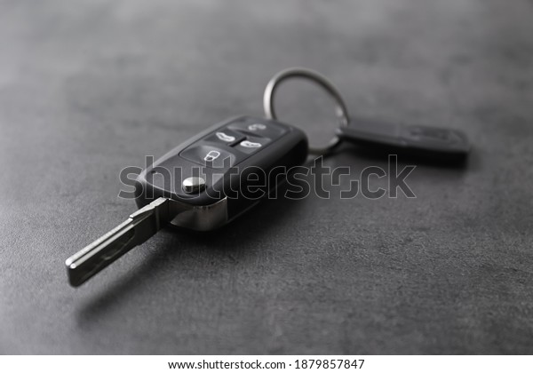 Modern car\
flip key with trinket on grey\
background