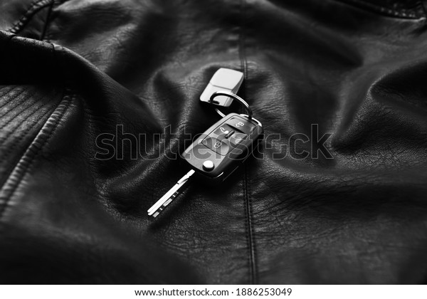 Modern car\
flip key with trinket on black\
leather