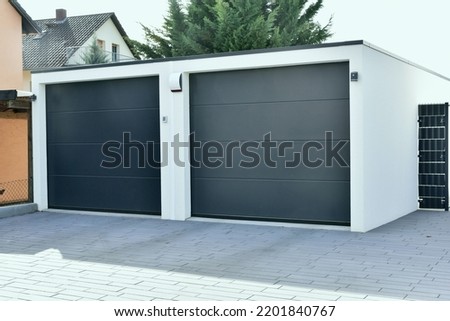 Modern Car Garage built of Concrete in Front of a residential Building