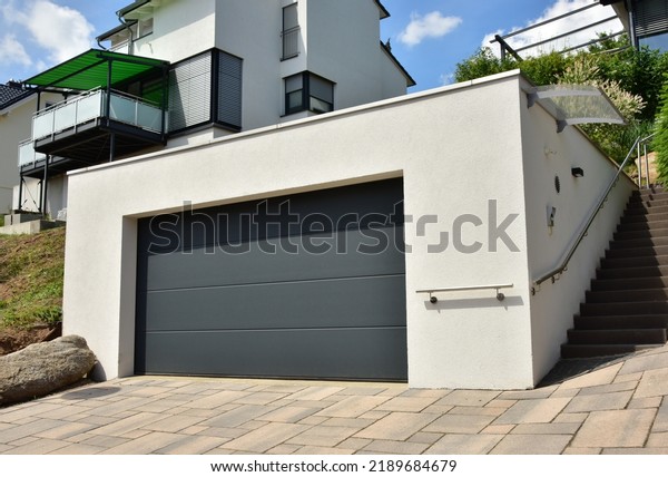 Modern Car Garage built of Concrete in Front of\
a residential Building