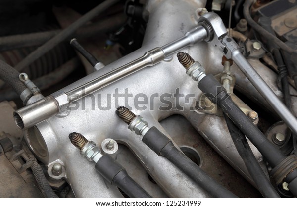 Modern car gasoline engine servicing,  ratchet tool
and spark plug