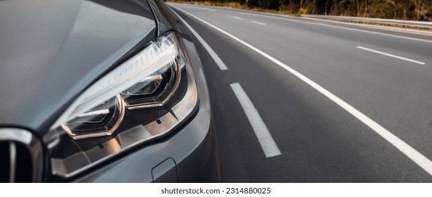 Modern car headlight close up view on the highway