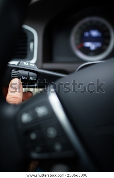 Modern car interior - driver pressing a button,\
using the car computer