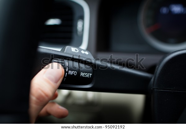 Modern car interior - driver pressing a button,\
using the car computer