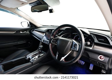 Modern car interior: steering wheel, gearshift lever, multimedia system, driver's seat and dashboard.