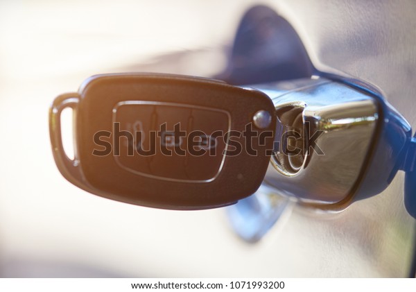 Modern car key\
inserted in handle macro close\
up