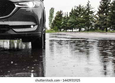 Modern car parked outdoors on rainy day