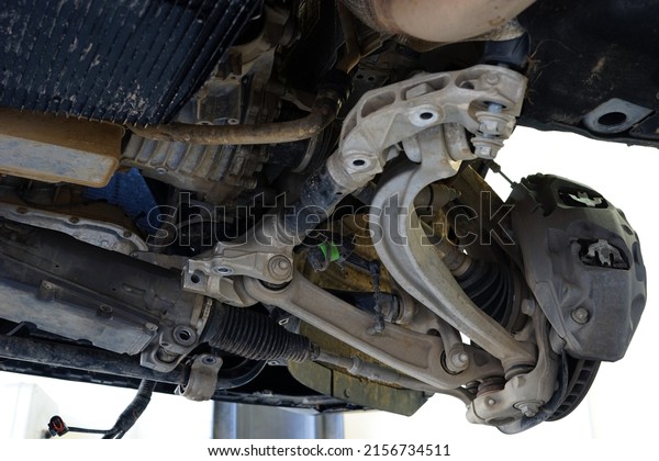 Modern car in a car service on a lift. Suspension\
repair. The structure and suspension elements of the car. Selected\
focus.