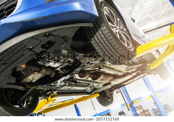 Modern Car Under\
Scheduled Maintenance Inside Auto Service. Vehicle Up on a Lift.\
Automotive Industry\
Theme.