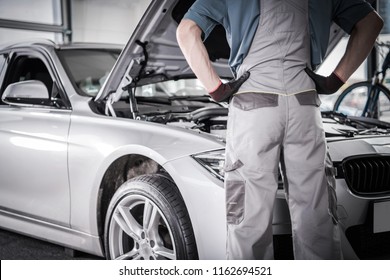 Modern Car Warranty Recall Fix. Mechanic In Front Of The Vehicle In The Authorized Service Center.