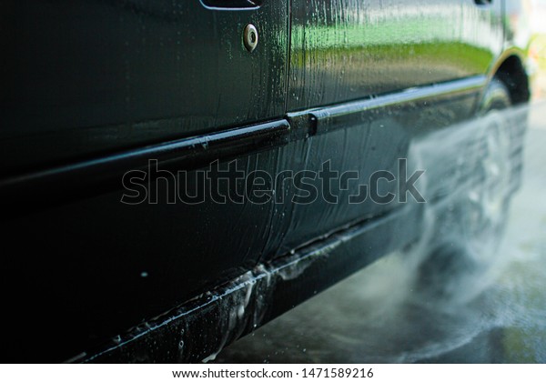 Modern car wash,\
dripping water and foam.