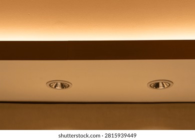 Modern ceiling design featuring recessed spotlights and concealed LED strip lighting, creating balanced illumination and clean architectural aesthetics for residential, office, or hospitality interiors.