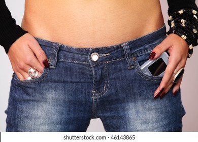 Modern cellphone sticking out of a jeans pocket