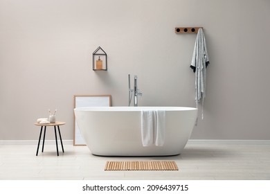 Modern ceramic bathtub near light wall indoors - Shutterstock ID 2096439715