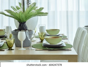 Modern Ceramic Tableware In Green Color Scheme Setting On Wooden Dining Table