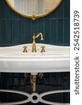 Modern ceramic wash basin with vintage style bronze faucet. Round mirror in golden canvas.Classic design .