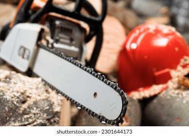 Modern chain saw and  firewood,closeup - Shutterstock ID 2301644173