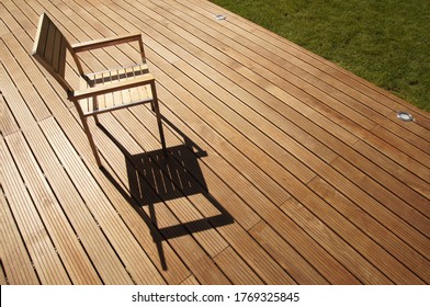 a modern chair on an exotic wood terrace on a sunny afternoon - Shutterstock ID 1769325845