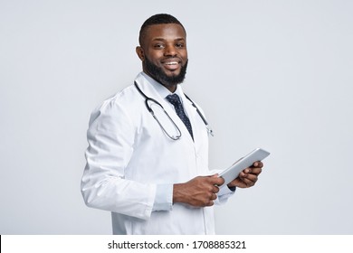 Modern Cheerful Black Medical Doctor Holding Digital Tablet, White Background, Copy Space