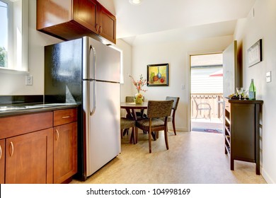 Modern Cherry Kitchen With Steal Appliances And Open Door.