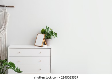 Modern Chest Of Drawers, Blank Frame And Houseplants Near White Wall