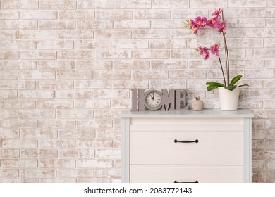 Modern chest of drawers with decor near brick wall in room - Shutterstock ID 2083772143