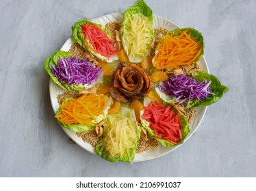 Modern Chinese fish salad. Yusheng aka Prosperity Toss. Mixed variety of vegetables with vibrant colors and  blend of smoked salmon slices to enhanced the taste.