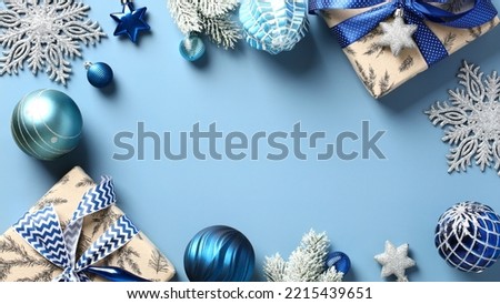 Modern Christmas holiday background with blue baubles, gift boxes, snowflakes, Xmas ornaments on pastel blue table. Elegant New Year poster template, winter holidays banner design.