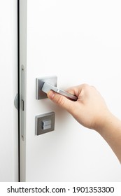 Modern chrome door handle and lock on white wooden door. Steel door handle