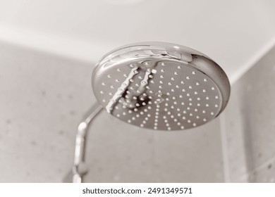 modern chrome showerhead with water droplets, against a blurred bathroom tile background Focus on hygiene home interior bathroom fixture, water conservation, and cleanliness restroom new design shower - Powered by Shutterstock