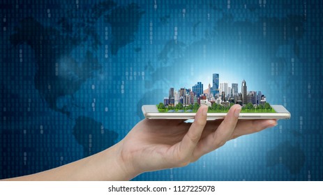 Modern city model on smartphone in women's hand holding with Abstract Blue Technology Background and world map. Binary Computer Code.