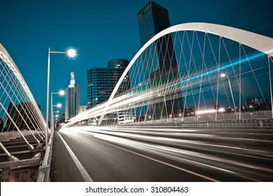 Modern city road arc ironbridge night landscape of car light trails in Tianjing