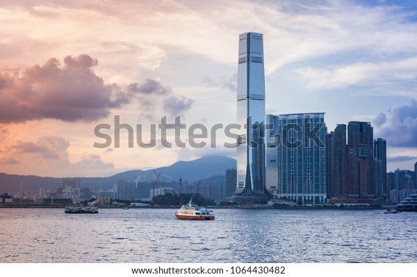 Modern cityscape with\
skyscrapers. International Commerce Centre of Hong Kong under\
colorful evening sky