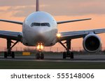 Modern civil passenger airliner taking off at airport during sunset.