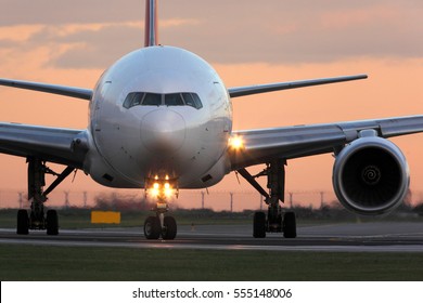Современный гражданский пассажирский авиалайнер, вылетающий в аэропорт во время заката.