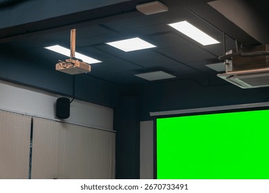 Modern classroom setup featuring a projector and a blank green screen, ideal for digital presentations and educational purposes, highlighting technology in learning.