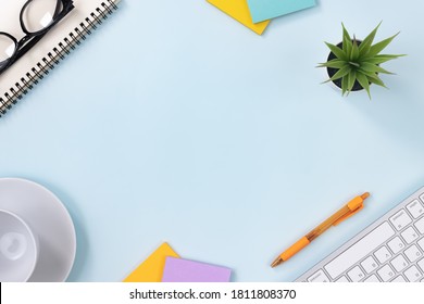 Modern Clean Office Desk Or Office Table On Top View And Stationery As Keyboard,Spiral Notebook,Pen,Stick Note,Office Plants,Glasses,Coffee Cup