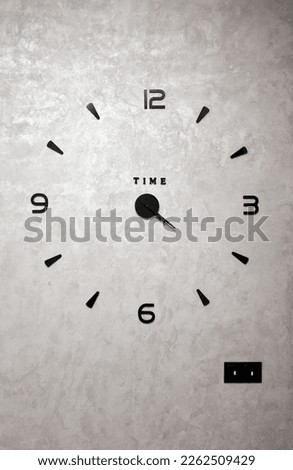 Modern clock. 3D clock on the wall with adhesive numbers without a case for the hall or living room. The wall is silvery with Venetian painting with a clock.