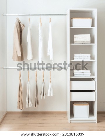 Modern closet with multiple clothes, featuring drawers, open shelves and towel racks