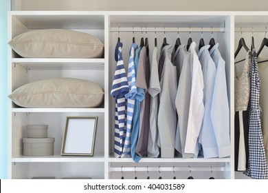 modern closet with row of cloths hanging in white wardrobe - Powered by Shutterstock