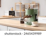 Modern coffee machine, beans and cup of espresso on wooden table in kitchen