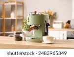 Modern coffee machine, beans and cup of espresso on wooden table in kitchen