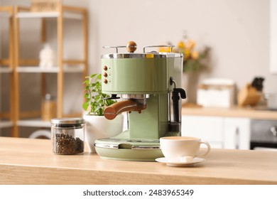 Modern coffee machine, beans and cup of espresso on wooden table in kitchen