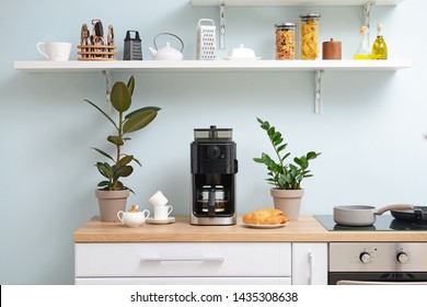 Modern coffee machine, cups and croissants on kitchen table
