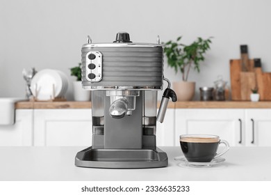 Modern coffee machine with glass cup of hot espresso on table in kitchen - Powered by Shutterstock