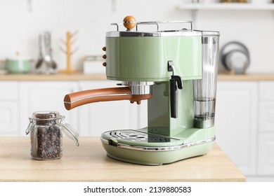 Modern coffee machine and jar of beans on counter in kitchen