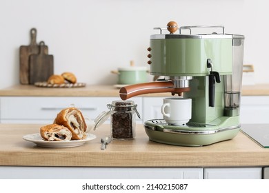 Modern coffee machine, jar of beans and croissant on counter in kitchen