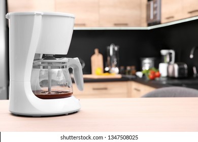 Modern Coffee Maker On Wooden Table In Kitchen. Space For Text