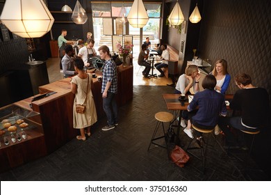 Modern Coffee Shop With Baristas And Various Customers Ordering 